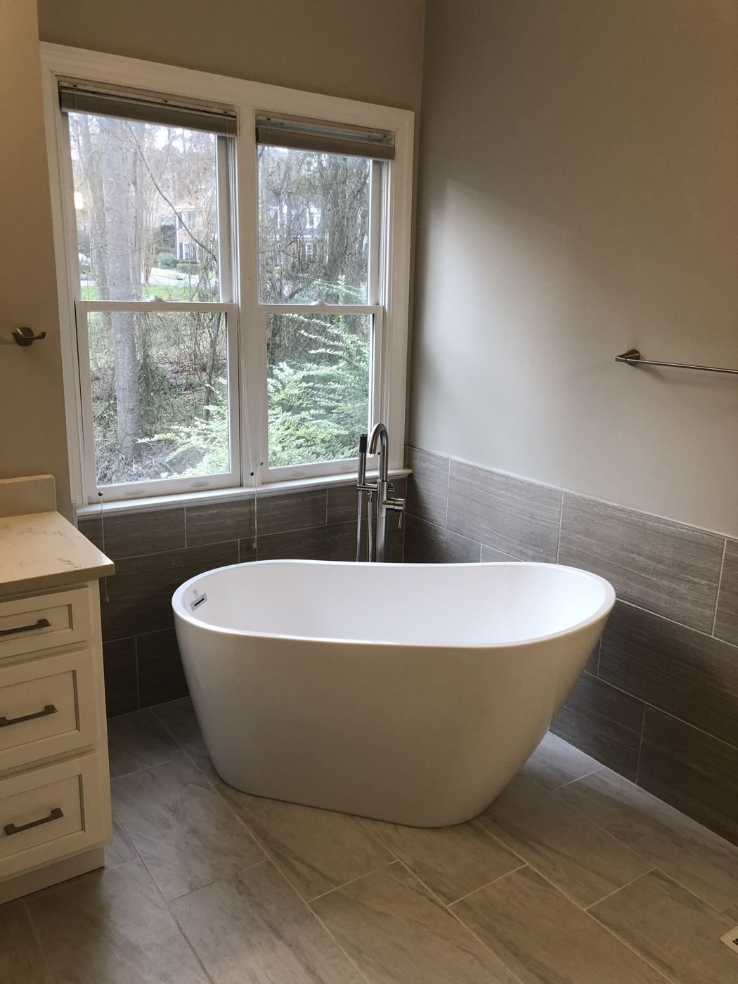 Freestanding tub with a tile wainscot and wood-look plank floor — Triangle Home Handyman, Apex NC