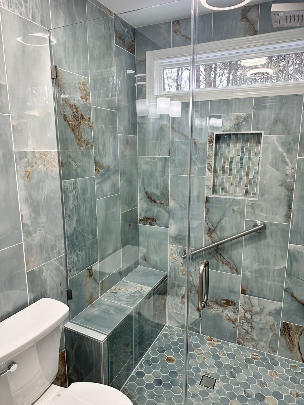 Glass shower with blue-green tile, a corner bench and hexagon mosaic floor — Triangle Home Handyman, Apex NC