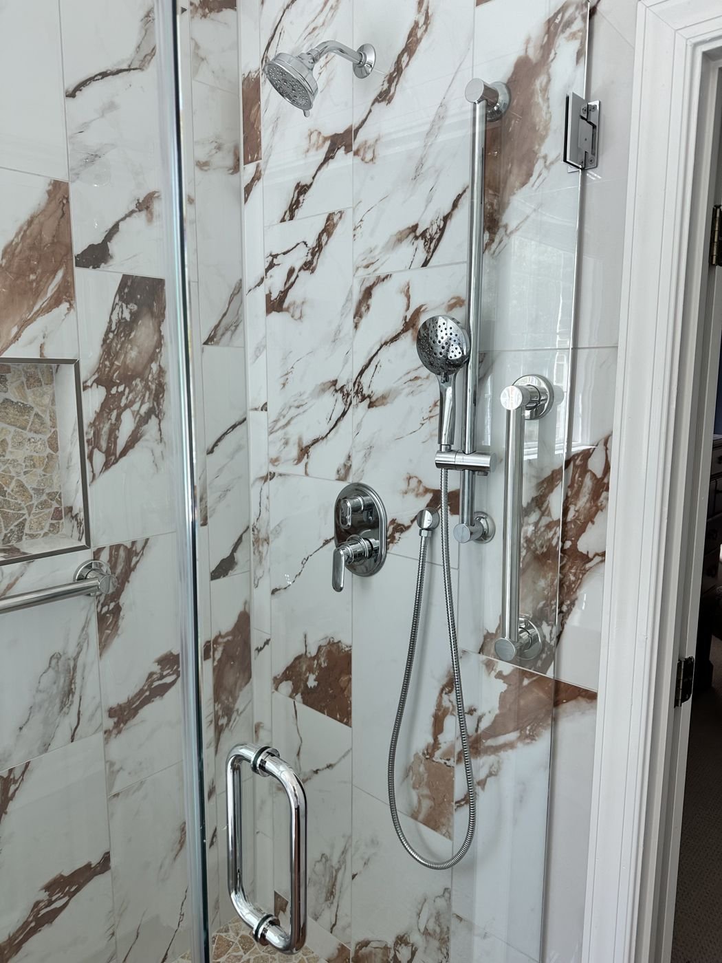 Glass shower with rust-veined marble-look tile and chrome fixtures — Triangle Home Handyman, Apex NC