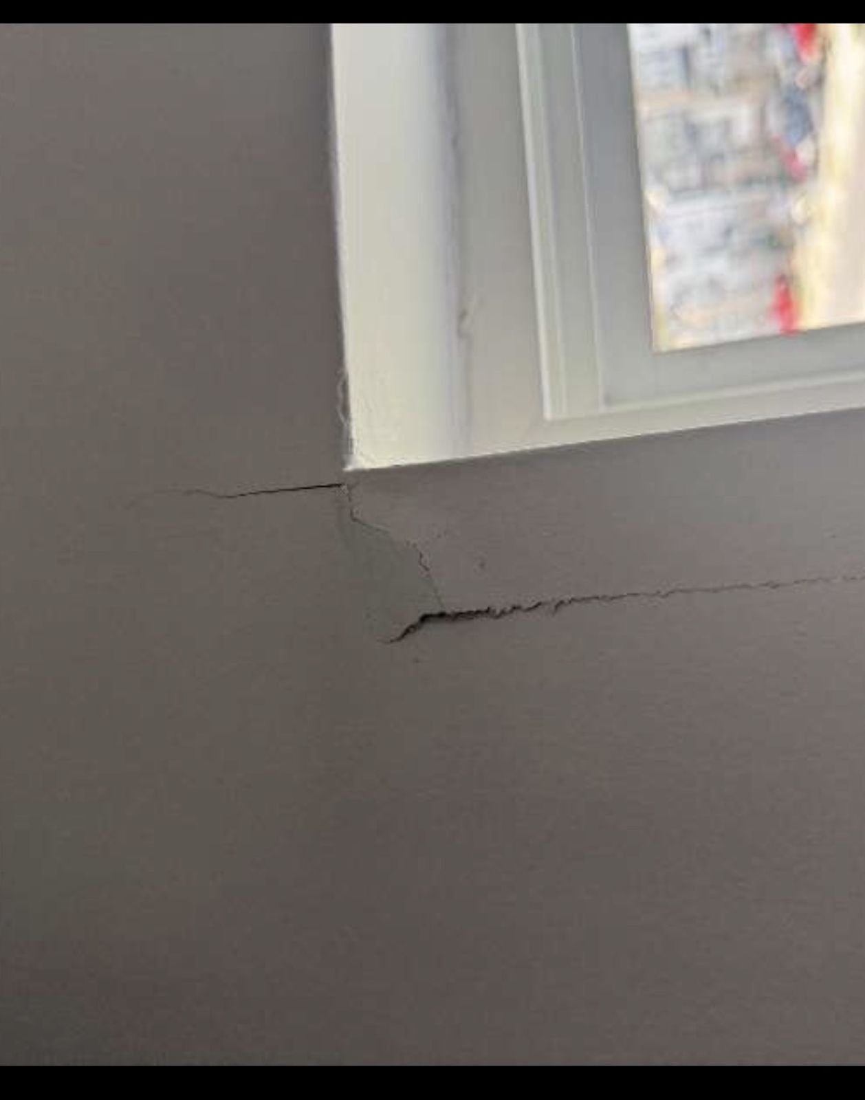 Long crack along the window sill line and corner before repair