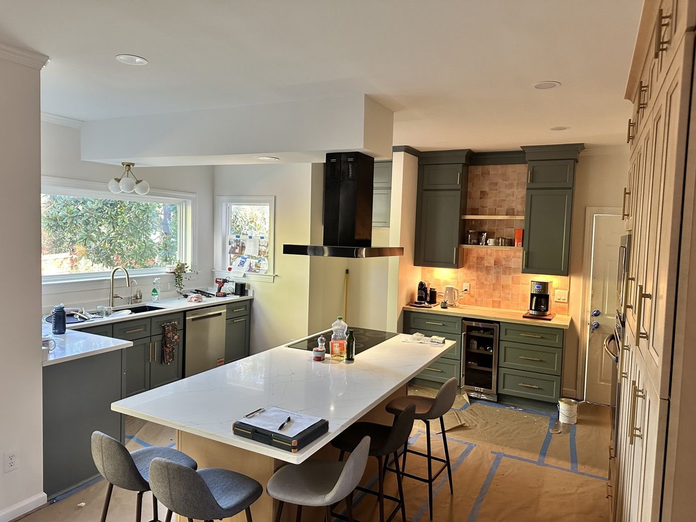 Kitchen remodel in progress: green lower cabinets, black range hood and quartz island with bar seating — Triangle Home Handyman, Apex NC
