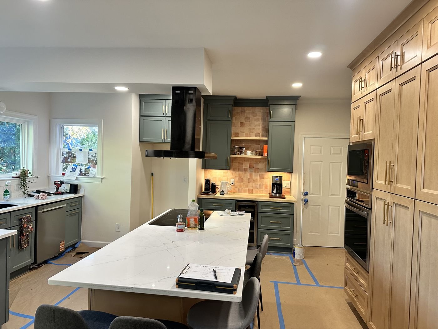Kitchen remodel with a wall of natural wood pantry cabinets and green lower cabinets — Triangle Home Handyman, Apex NC