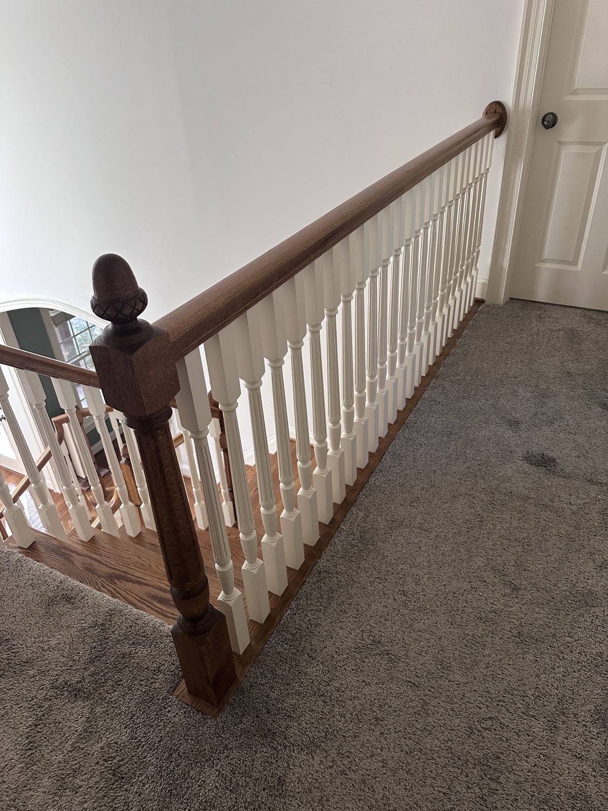Stair railing with an oak newel post and acorn finial at the top of the stairs, Holly Springs NC — Triangle Home Handyman, Apex NC